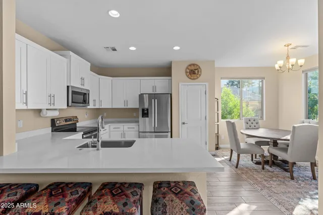 a kitchen with stainless steel appliances granite countertop a sink a stove a microwave a refrigerator and cabinets