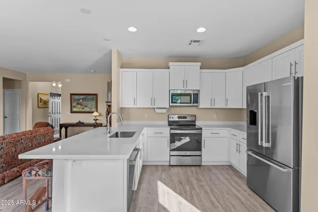 a kitchen with stainless steel appliances a refrigerator sink stove microwave and cabinets