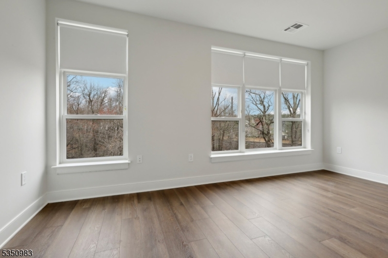 434 Springfield Avenue, Unit 119 Berkeley Heights, NJ 07922 - Photo 13 of 29 an empty room with wooden floor and a window