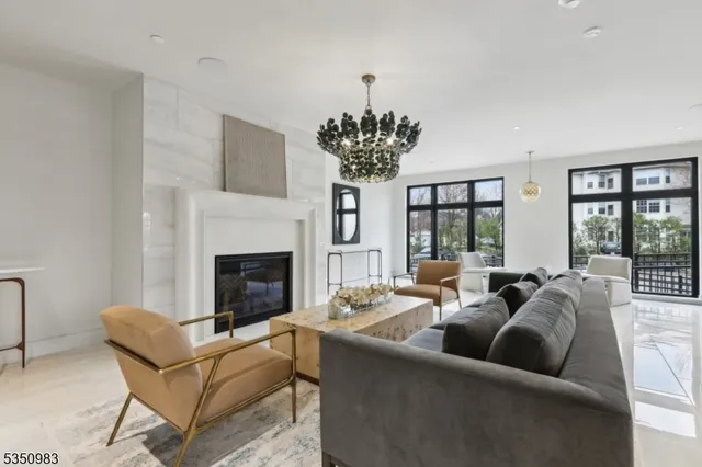 a living room with furniture a chandelier and a fireplace