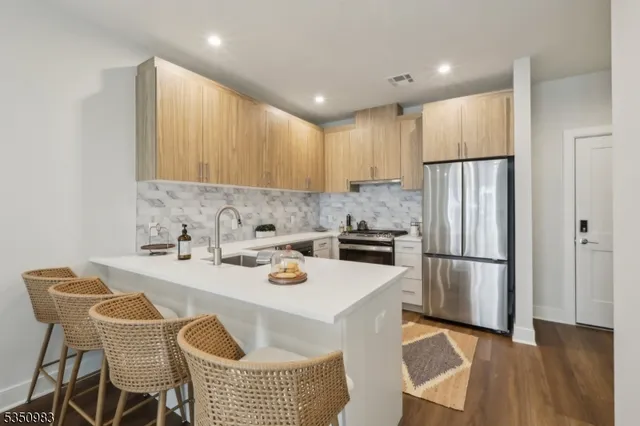 a kitchen with a refrigerator a stove a sink and a dining table