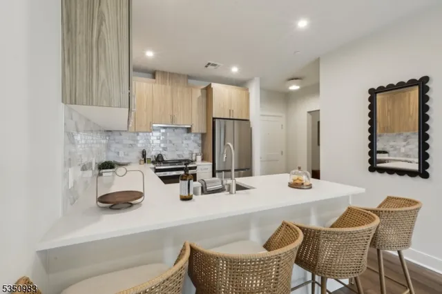 a kitchen with stainless steel appliances granite countertop a table chairs and a refrigerator