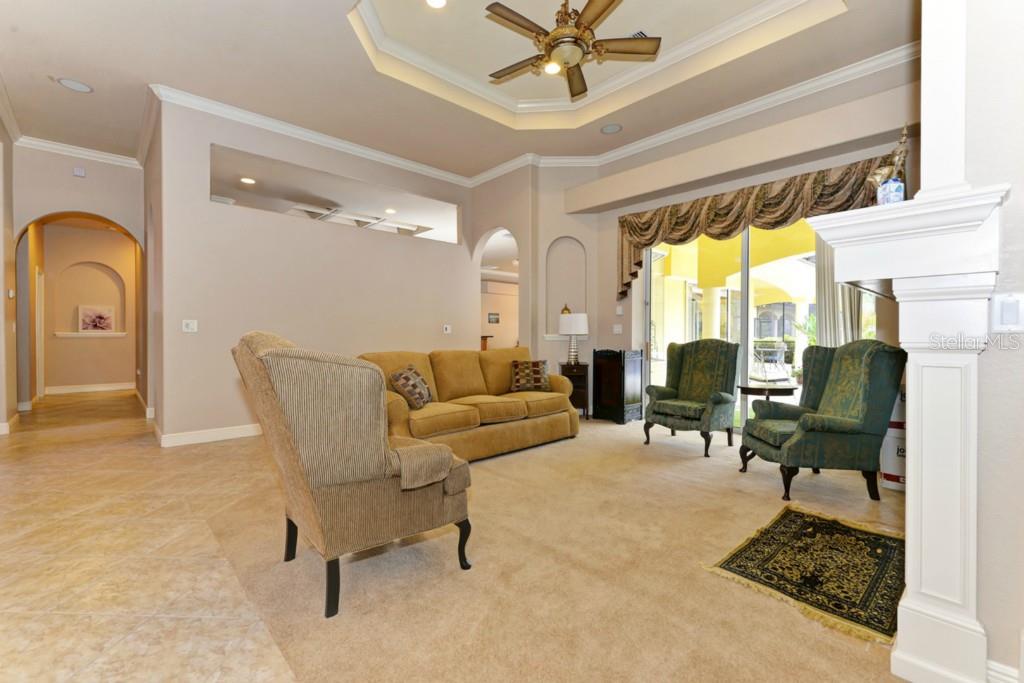 3302 Twin Rivers Trail Parrish, FL 34219 - Photo 4 of 24 Double door entry with columns leads you to the formal living room with a gas fireplace, high ceilings, crown molding and recessed ceiling with beautiful lighting. Sliders open to pool