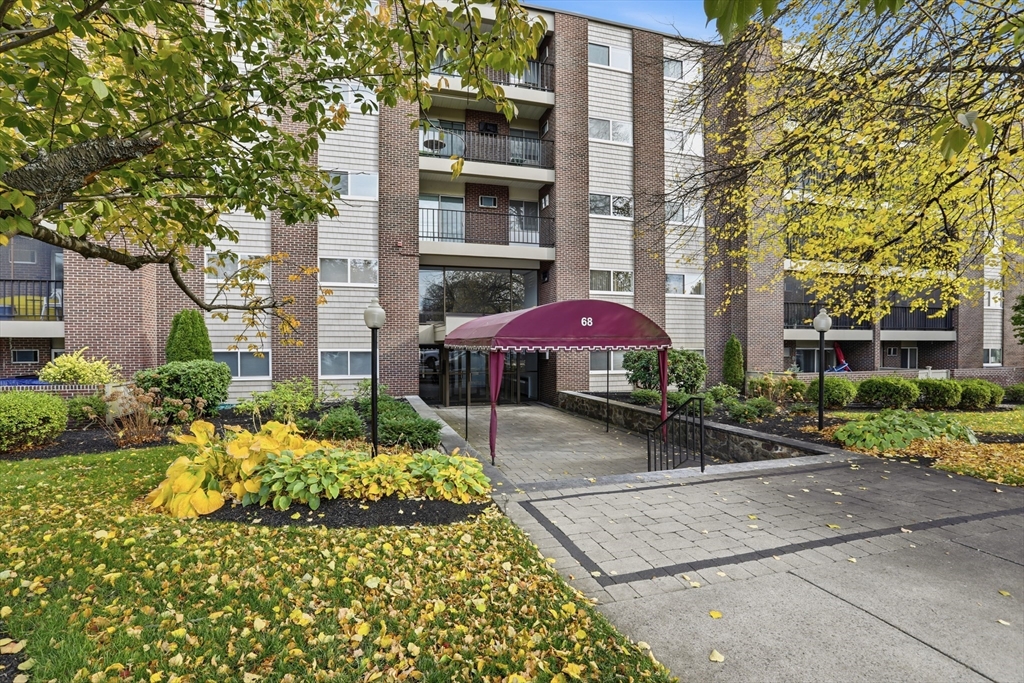 68 Main Street, Unit 36C Stoneham, MA 02180 - Photo 1 of 19 a view of a patio with a table and chairs under an umbrella