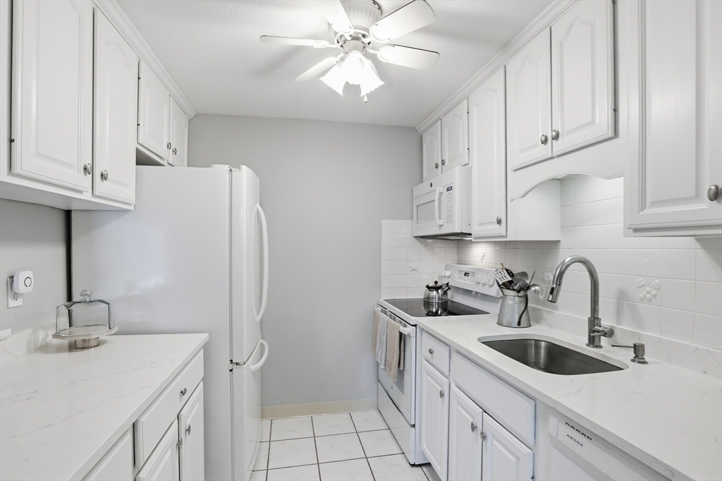 68 Main Street, Unit 36C Stoneham, MA 02180 - Photo 11 of 19 a kitchen with a sink cabinets and refrigerator