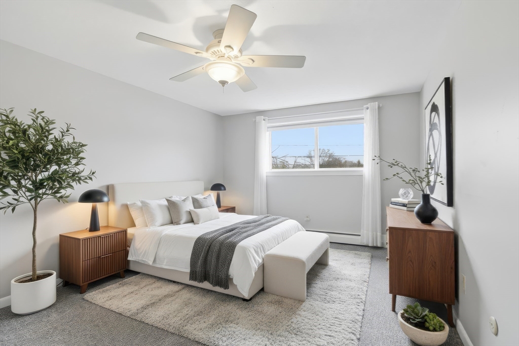 68 Main Street, Unit 36C Stoneham, MA 02180 - Photo 12 of 19 a bedroom with bed and a chandelier