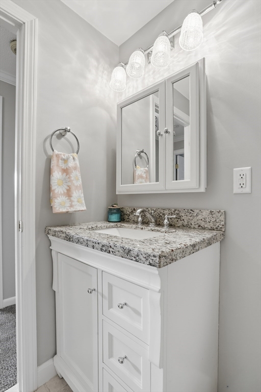 68 Main Street, Unit 36C Stoneham, MA 02180 - Photo 14 of 19 a bathroom with a granite countertop sink and a mirror