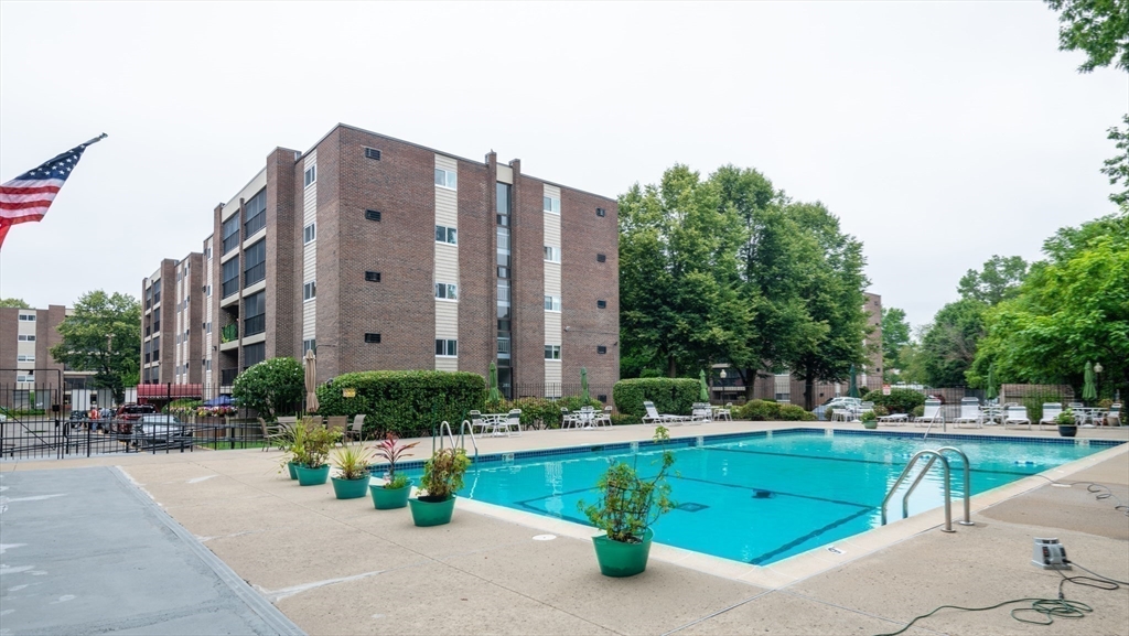 68 Main Street, Unit 36C Stoneham, MA 02180 - Photo 17 of 19 a view of swimming pool with outdoor seating and house in the background