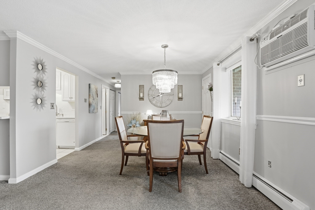 68 Main Street, Unit 36C Stoneham, MA 02180 - Photo 6 of 19 a view of a dining room with furniture a chandelier and wooden floor