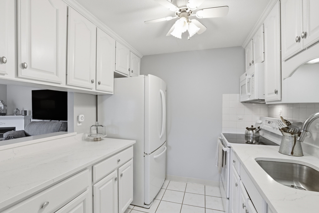 68 Main Street, Unit 36C Stoneham, MA 02180 - Photo 10 of 19 a kitchen with stainless steel appliances a sink a refrigerator and cabinets