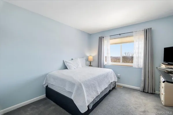a bedroom with a bed and a flat tv screen on a dresser
