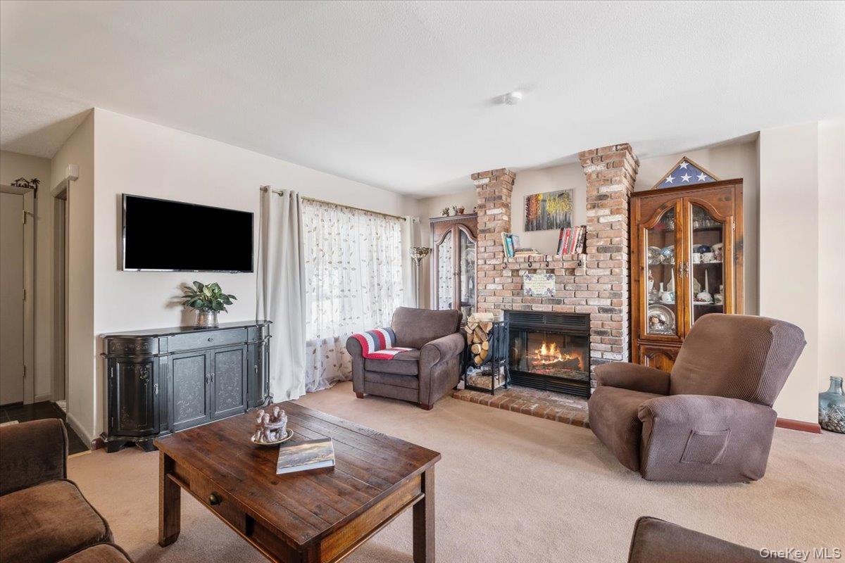 1707 Eagles Ridge Road Brewster, NY 10509 - Photo 5 of 50 a living room with furniture a flat screen tv and a fireplace