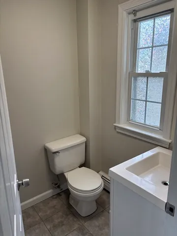 a white toilet sitting next to a window