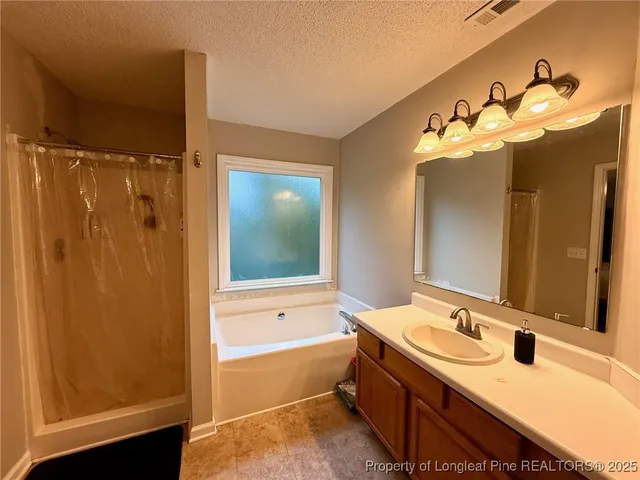 a bathroom with a tub sink and mirror