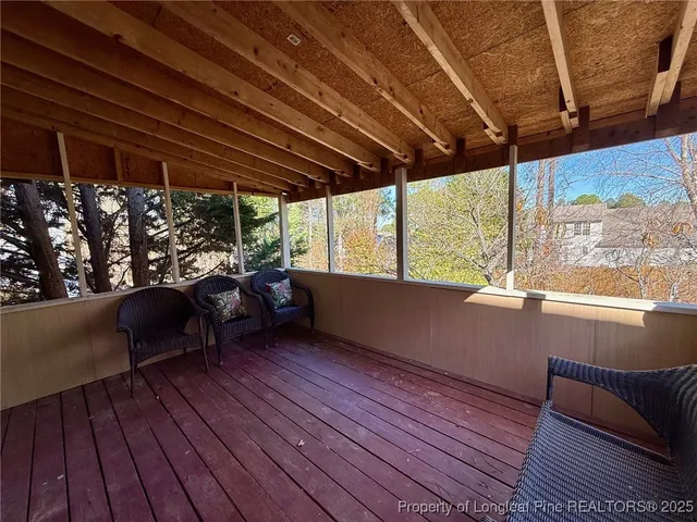 a balcony with wooden floor and outdoor seating