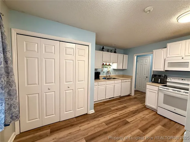 a kitchen with white cabinets and white appliances