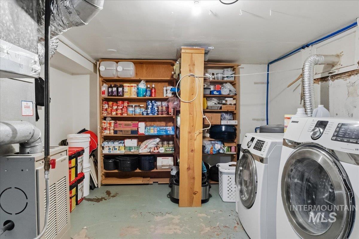1958 East 1775 South Gooding, ID 83330 - Photo 32 of 49 Utility space featuring a front-loading washer and dryer, built-in wooden shelving, and exposed ductwork