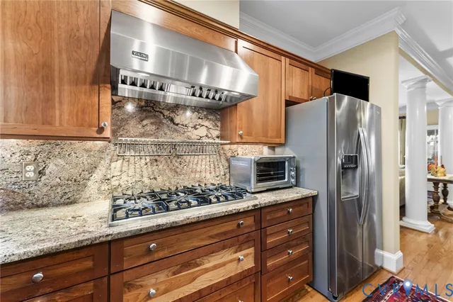 a kitchen with stainless steel appliances granite countertop a refrigerator and a stove