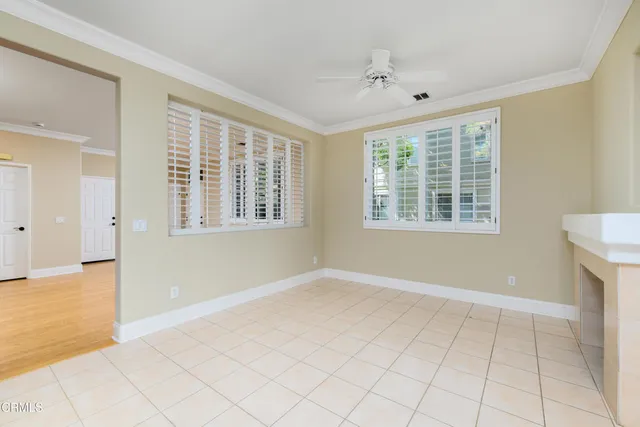 a view of an empty room with window and hardwood floor