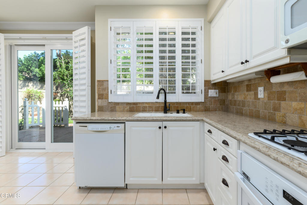 353 Via Cantilena Camarillo, CA 93012 - Photo 18 of 42 a kitchen with granite countertop white cabinets and a window