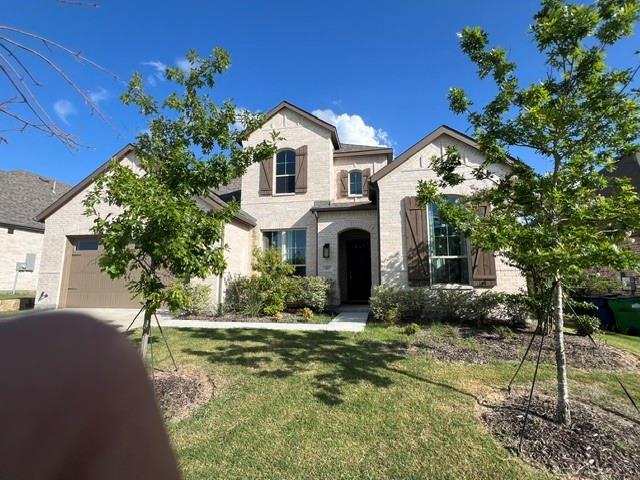 1407 Cartona Road Fate, TX 75087 - Photo 2 of 21 Two-story brick exterior featuring a multi-gable roofline, arched entry, and dark wood shutters