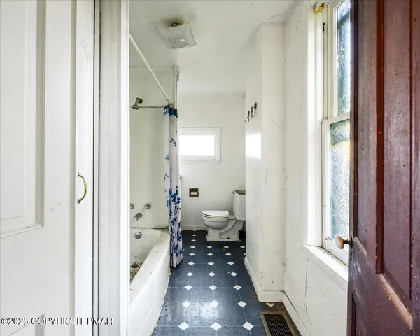 a view of a room with wooden floor and windows