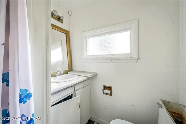 a view of a room with a large window and wooden floor