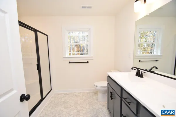 a bathroom with a sink a toilet and shower