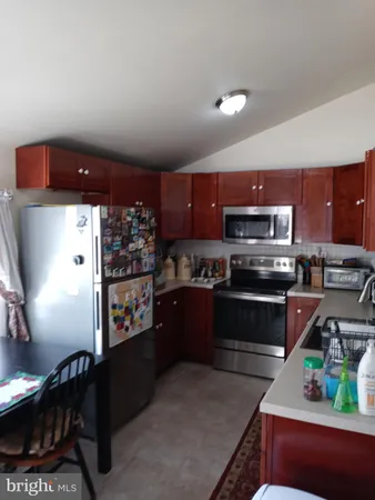 a kitchen with stainless steel appliances kitchen island granite countertop a refrigerator and a stove top oven