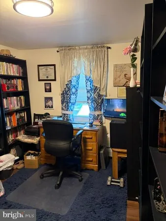 a view of a workspace with furniture and a window