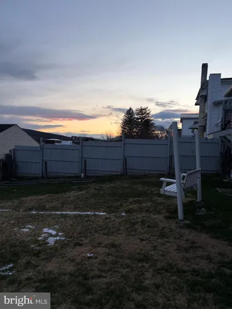a view of a yard with wooden fence