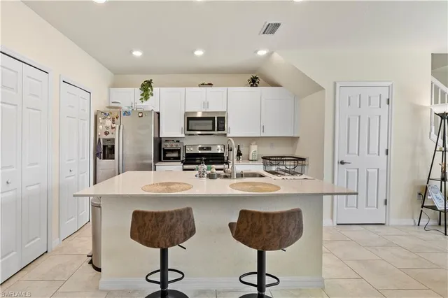 a kitchen with a dining table chairs and white cabinets