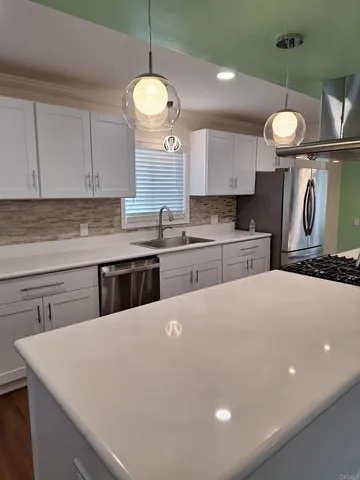 a kitchen with a stove a sink a center island and cabinets