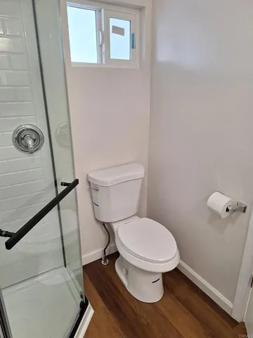 a white toilet sitting next to a shower
