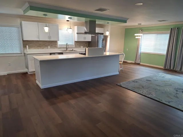 a large kitchen with kitchen island a stove a sink and a refrigerator