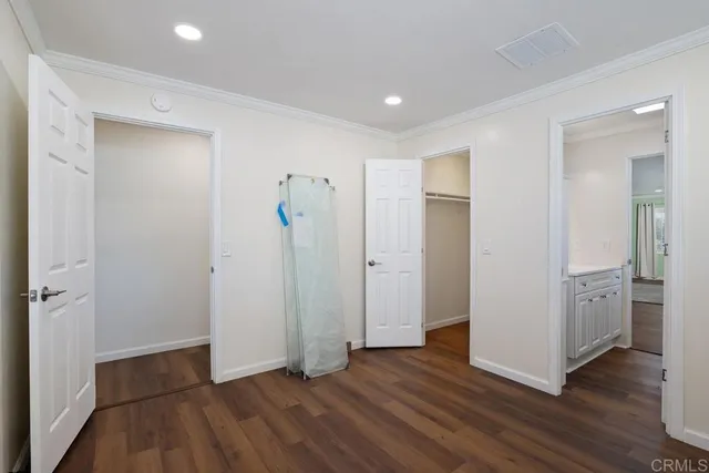 a view of an empty room with wooden floor and closet