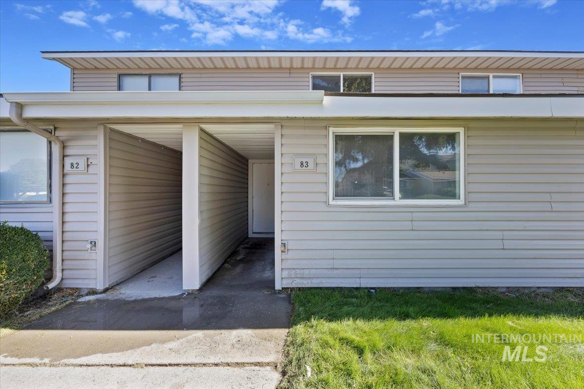 259 Pheasant Road, Unit 83 Twin Falls, ID 83301 - Photo 1 of 26 Light-colored horizontal siding exterior featuring a white entry door, multiple windows, and a covered walkway