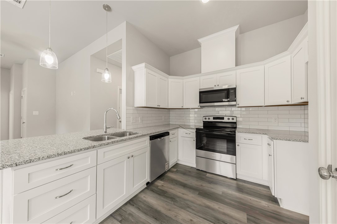 1801 Pin Oak Street Bryan, TX 77803 - Photo 8 of 17 a kitchen with granite countertop white cabinets white stainless steel appliances and a sink