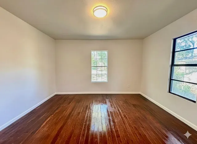 wooden floor in an empty room with a window