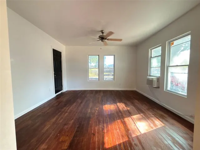 an white kitchen with granite countertop cabinets and wooden floor