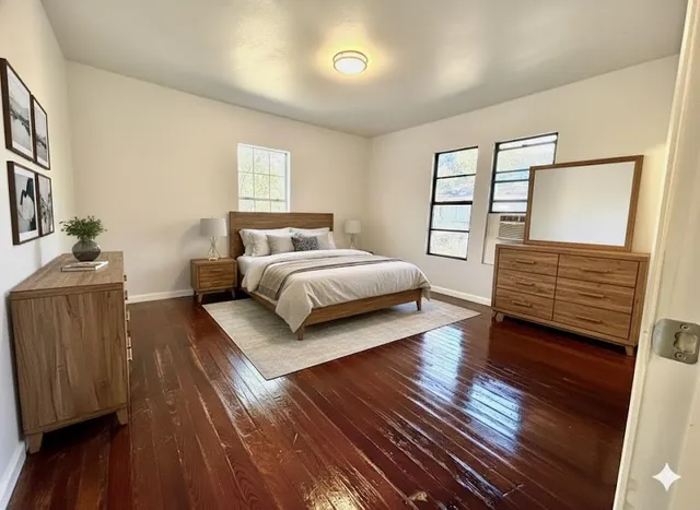 a bedroom with a bed and wooden floor