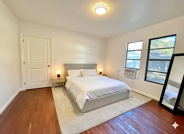 a bedroom with a bed and a large window