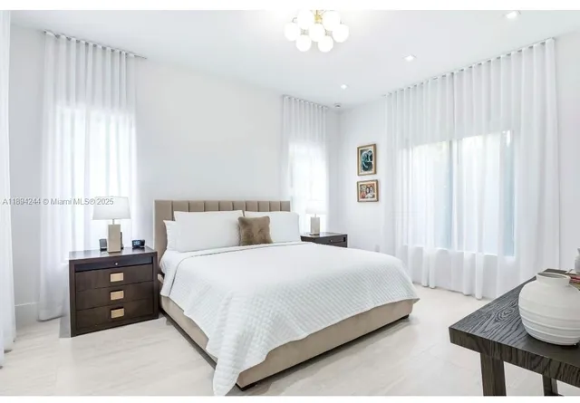 a bedroom with a bed and a chandelier