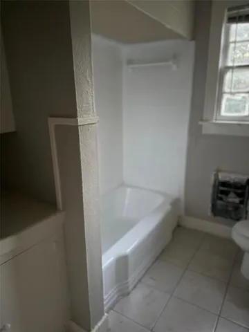 a bathroom with a tub a sink and a window