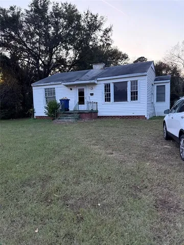 a view of a yard in front of a house with large trees