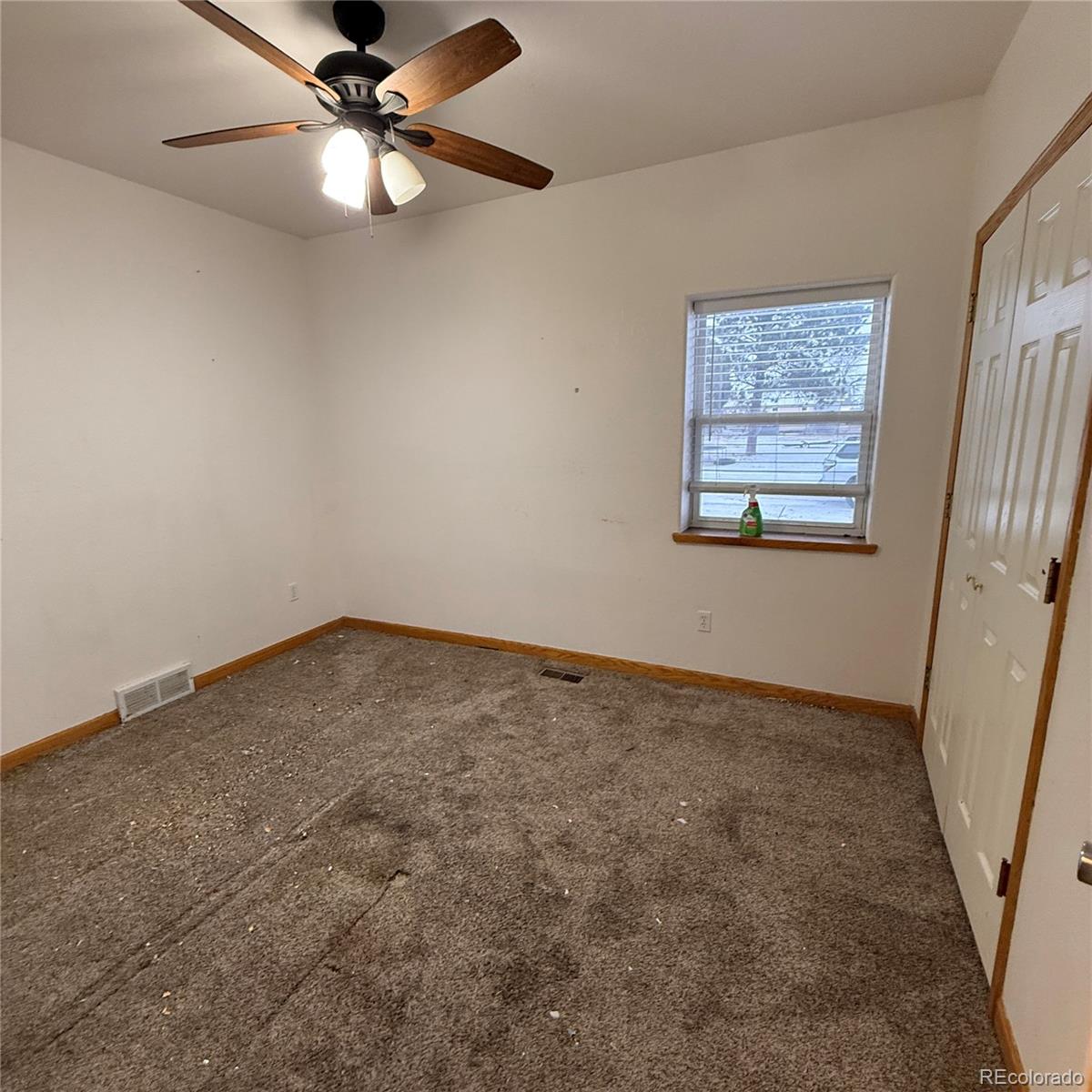 209 West Hall Street Fleming, CO 80728 - Photo 7 of 7 an empty room with a window and a fan