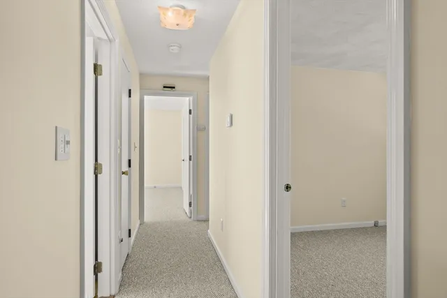 a view of a hallway with closet and bathroom