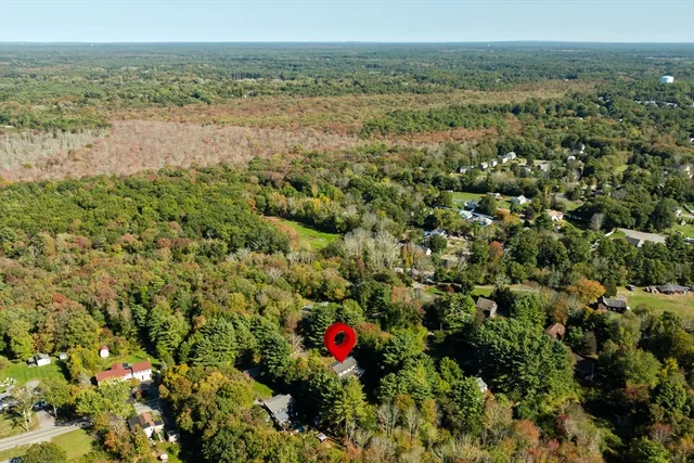 an aerial view of a houses with a lush green hillside