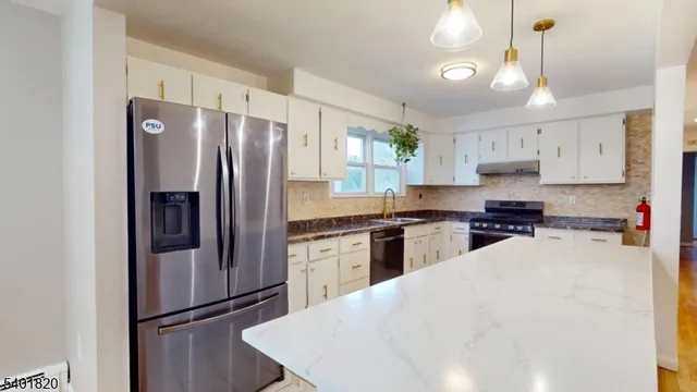 a kitchen with granite countertop a refrigerator stove top oven and sink