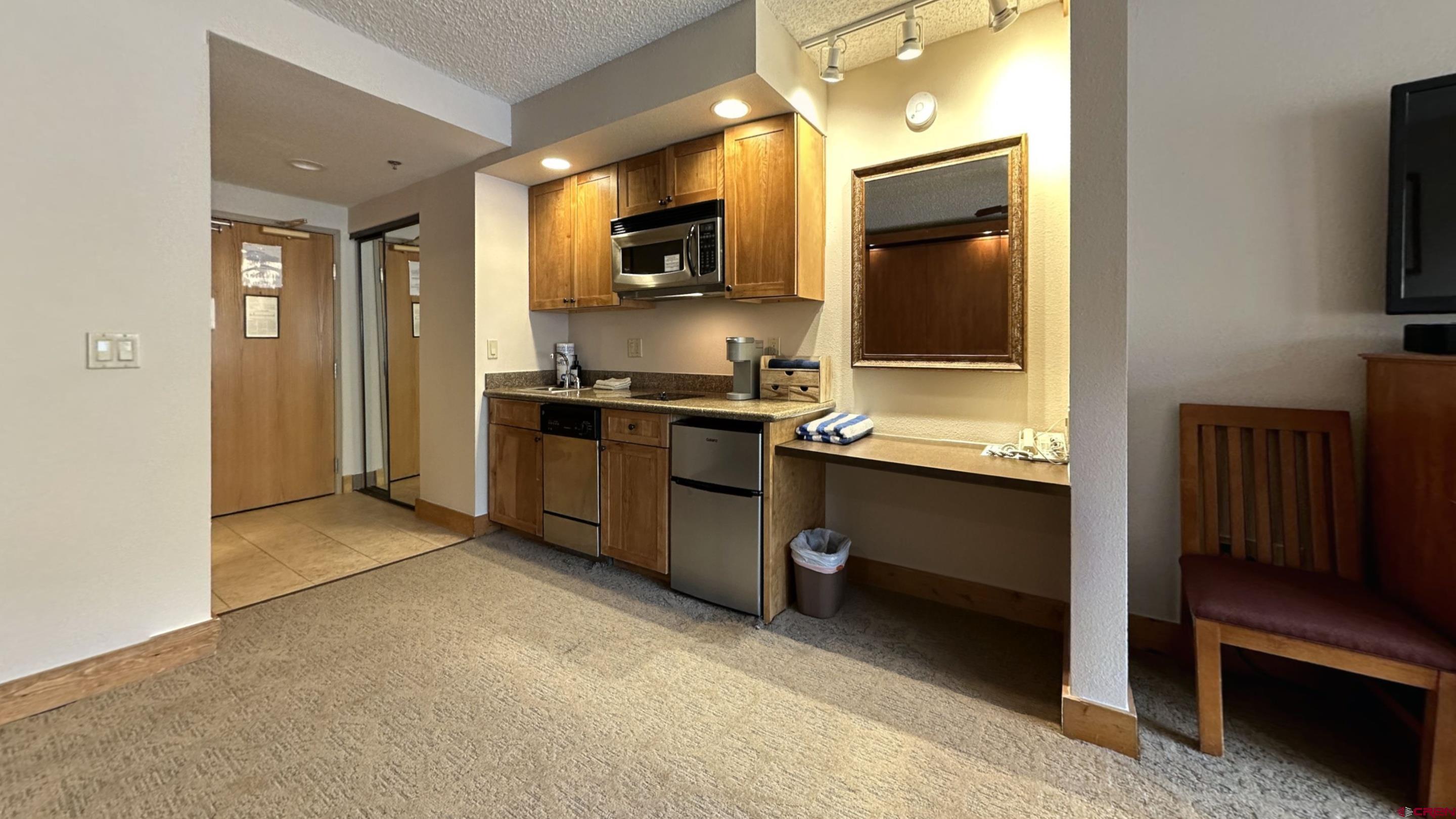 6 Emmons Road, Unit 317 Crested Butte, CO 81225 - Photo 3 of 19 a kitchen with stainless steel appliances granite countertop a stove a sink and a microwave